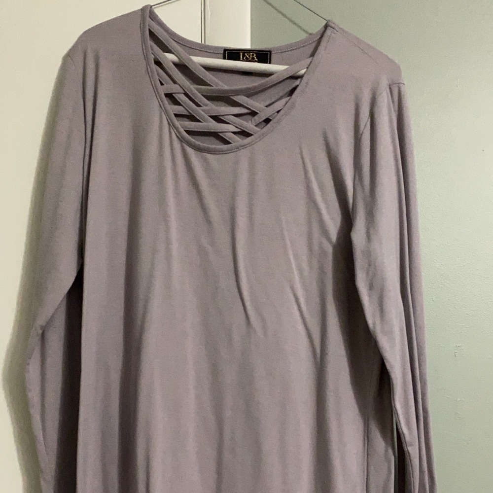 Long sleeve, light purple top. Long shirt tail, would fit medium. Has stretch.
